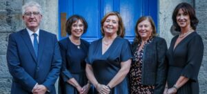 Five people at a blue door